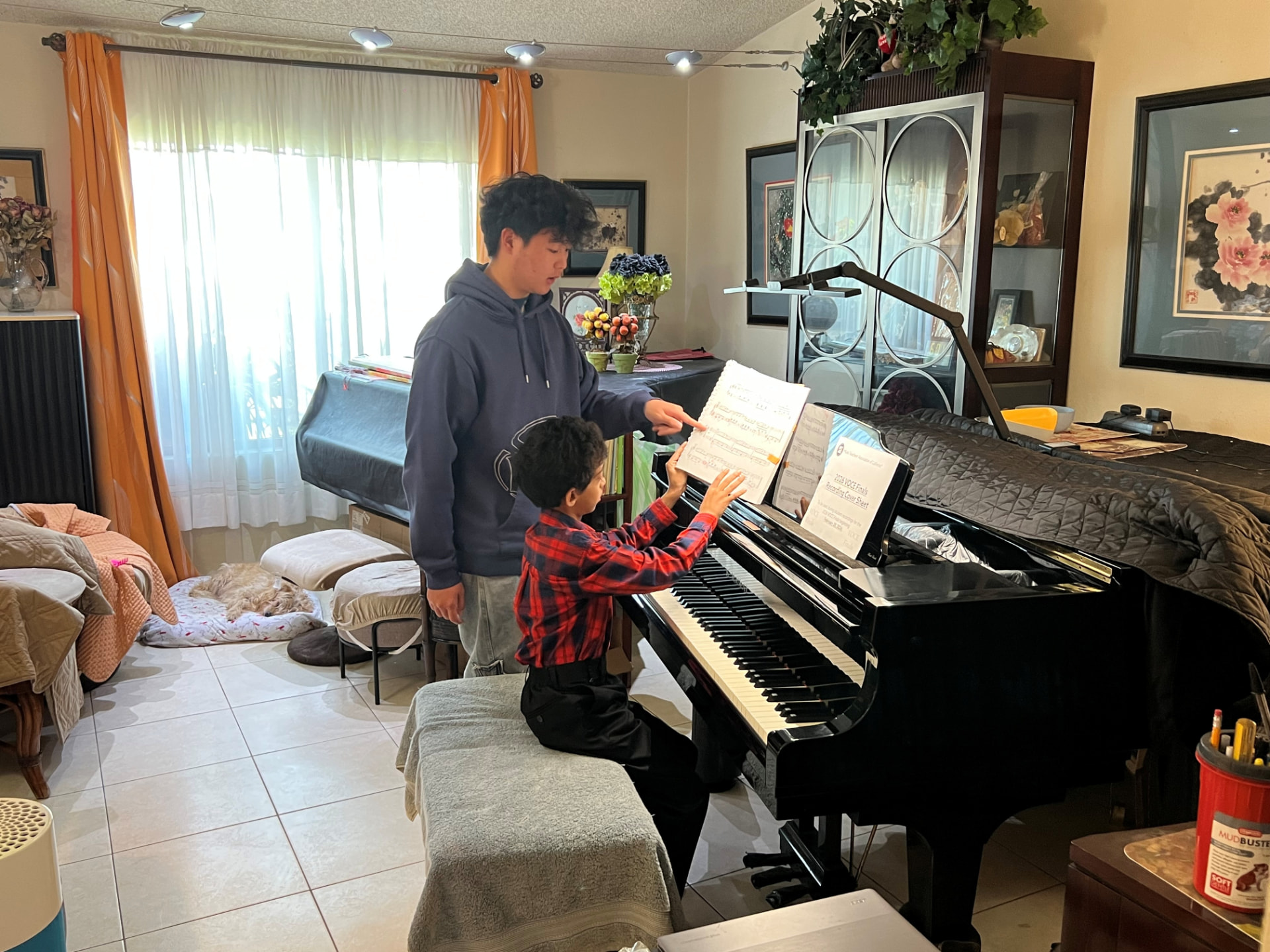 Brendan Li pointing out a passage in the score for a young student